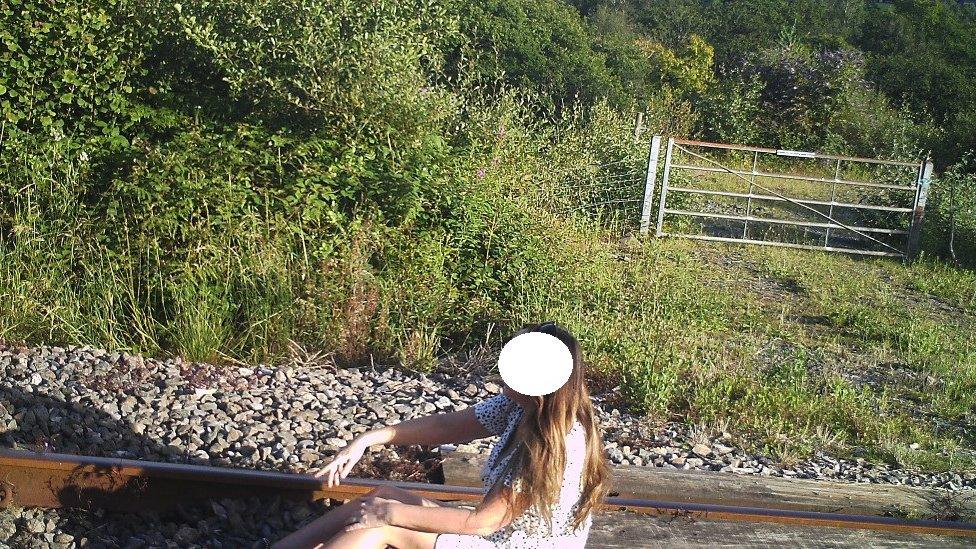 A woman sits on the track