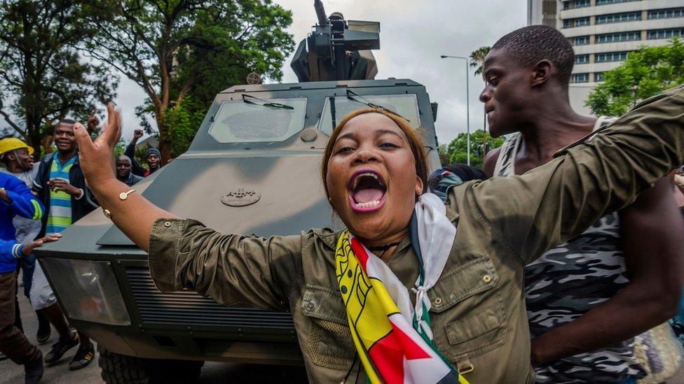 woman singing and dancing in front of army tank