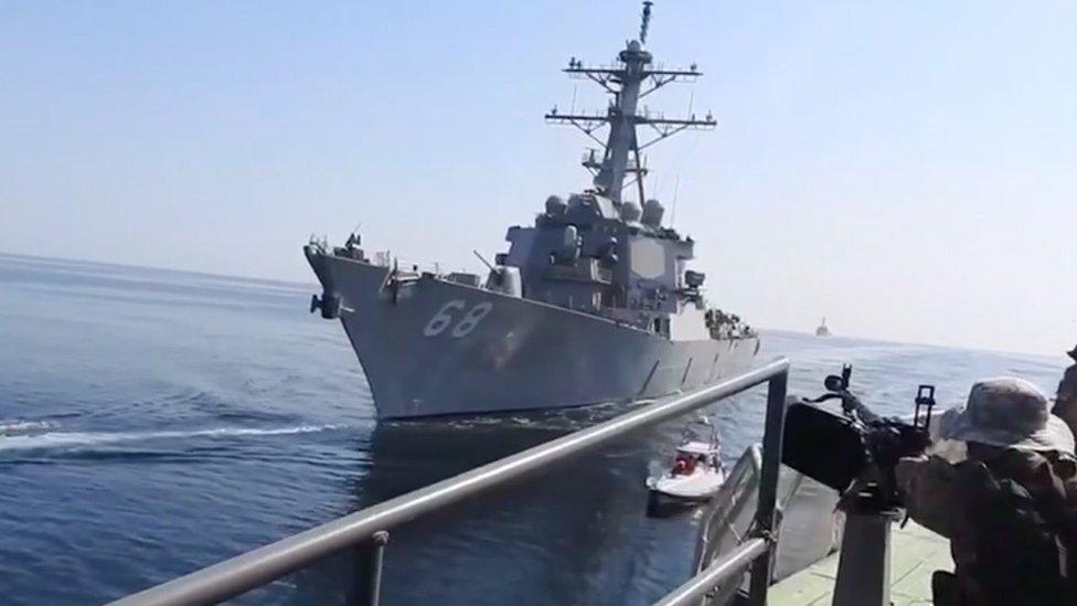 A grab taken from a video made available by Iran's Islamic Revolution Guard Corps (IRGC) on 3 November 2021 shows a Revolutionary Guard aiming a machine-gun at a US warship in the Gulf of Oman during an incident involving a Vietnam-flagged oil tanker in the Gulf of Oman