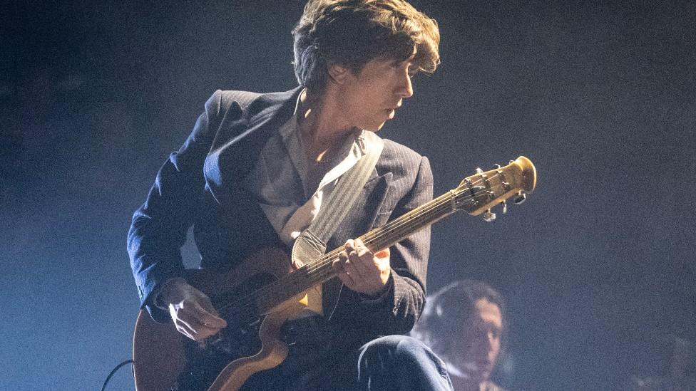 Arctic Monkeys frontman Alex Turner later threw off his jacket, put down his guitar and put on his shades to sing