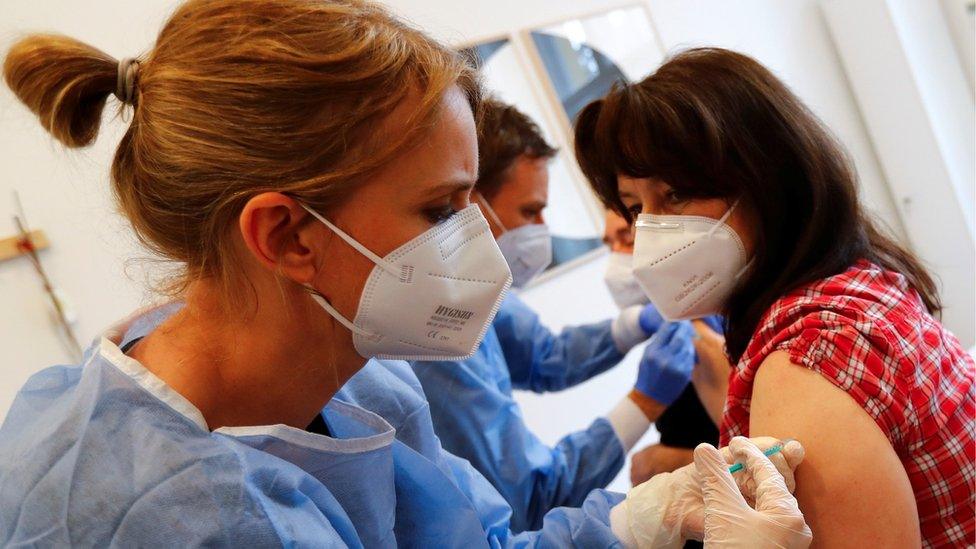 A couple receives a dose of the Pfizer-BioNTech vaccine in Berlin, Germany