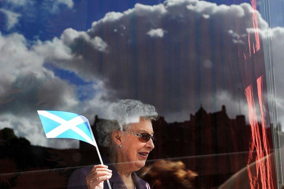 Edinburgh Castle is seen reflected in a window as a members at The Royal Over-Seas League watches as Pope Benedict XVI is driven along Princes Street in Edinburgh, Scotland on September 16, 2010.