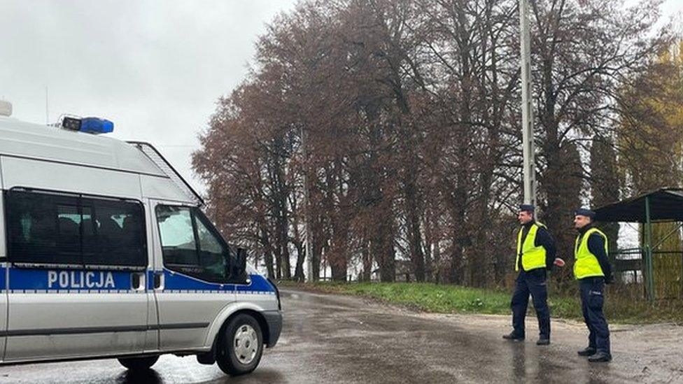 Police officers walk next to a police vehicle at a blockade after an explosion in Przewodow, a village in eastern Poland near the border with Ukraine, November 16, 2022. R