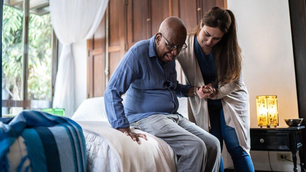 Female carer looking after a man at home