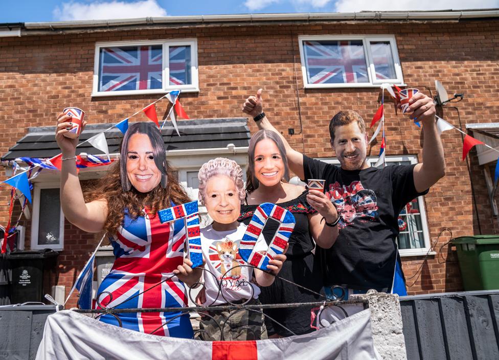 A family wear masks depicting members of the royal family, at a Jubilee Street Party in Trafford, Manchester, on 4 June 2022