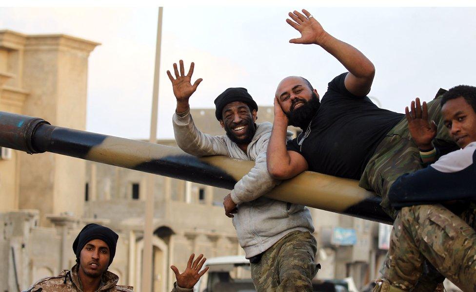 Fighters rest on a big gun and wave at the camera in Benghazi, Libya - Saturday 14 January 2017