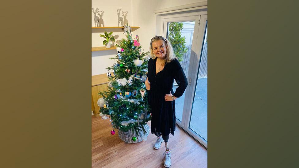 Tracy Ralph in front of a Christmas tree