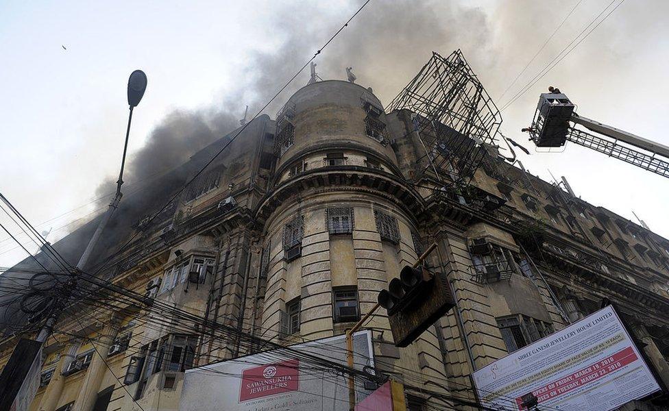 Indian fire-fighters spray water to control a fire on a building in Kolkata on March 23, 2010.