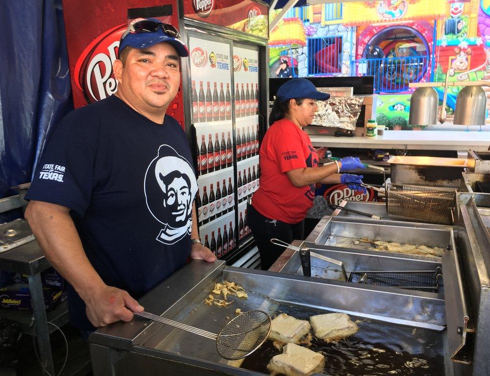 Two stall owners fry food in deep fat fryers