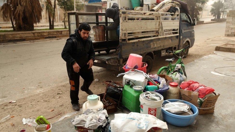 A man loads a truck as Syrian government forces bear down on Maaret Al-Numan