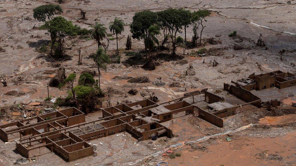 The debris of a school in a district covered in mud after the dam collapse