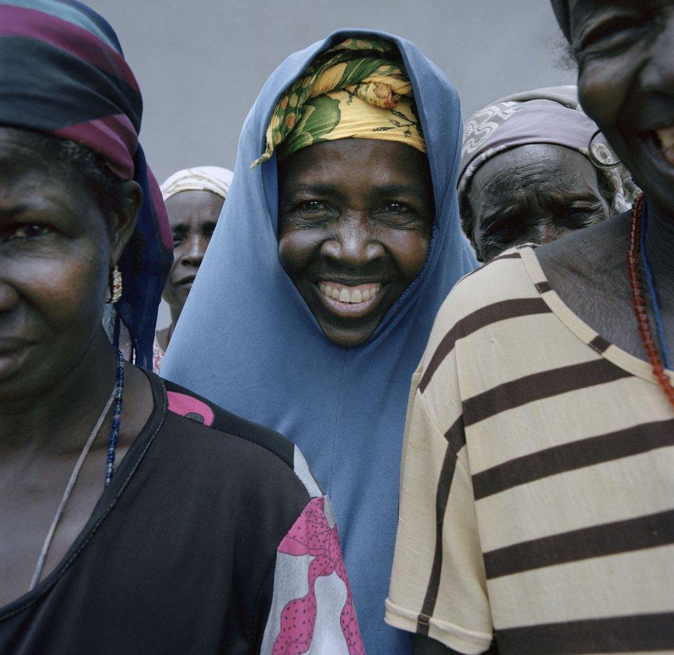 A woman smiles out from a group.