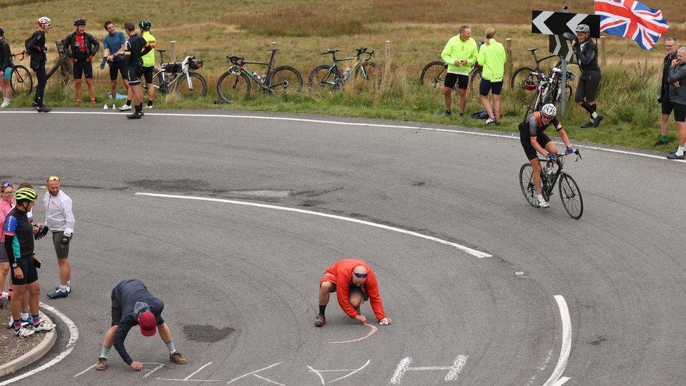 Spectators write a message on the road at Hartside Pass in Alston