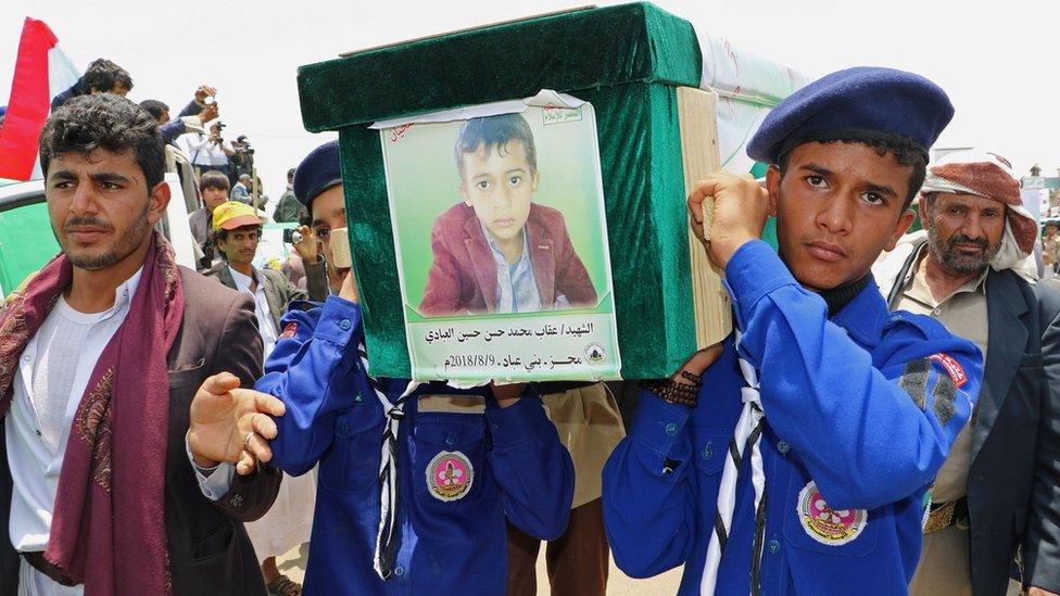 Scouts carry the coffin of a boy during the funerals on 13 August 2018 of people killed in a Saudi-led coalition air strike in Saada, Yemen.