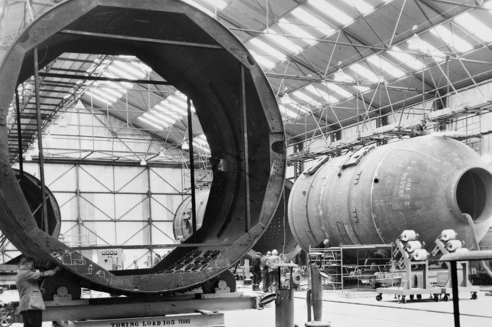 Large tube sections being moved in a factory