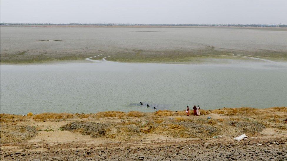 Women stand by the dried-up puzhal reservoir on the outskirts of Chennai, capital of the southern Indian state of Tamil Nadu, Wednesday, June 20, 2019.