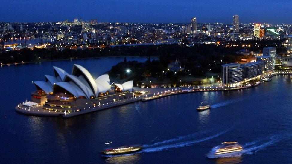 A night view of the Sydney Opera House and the city beyond