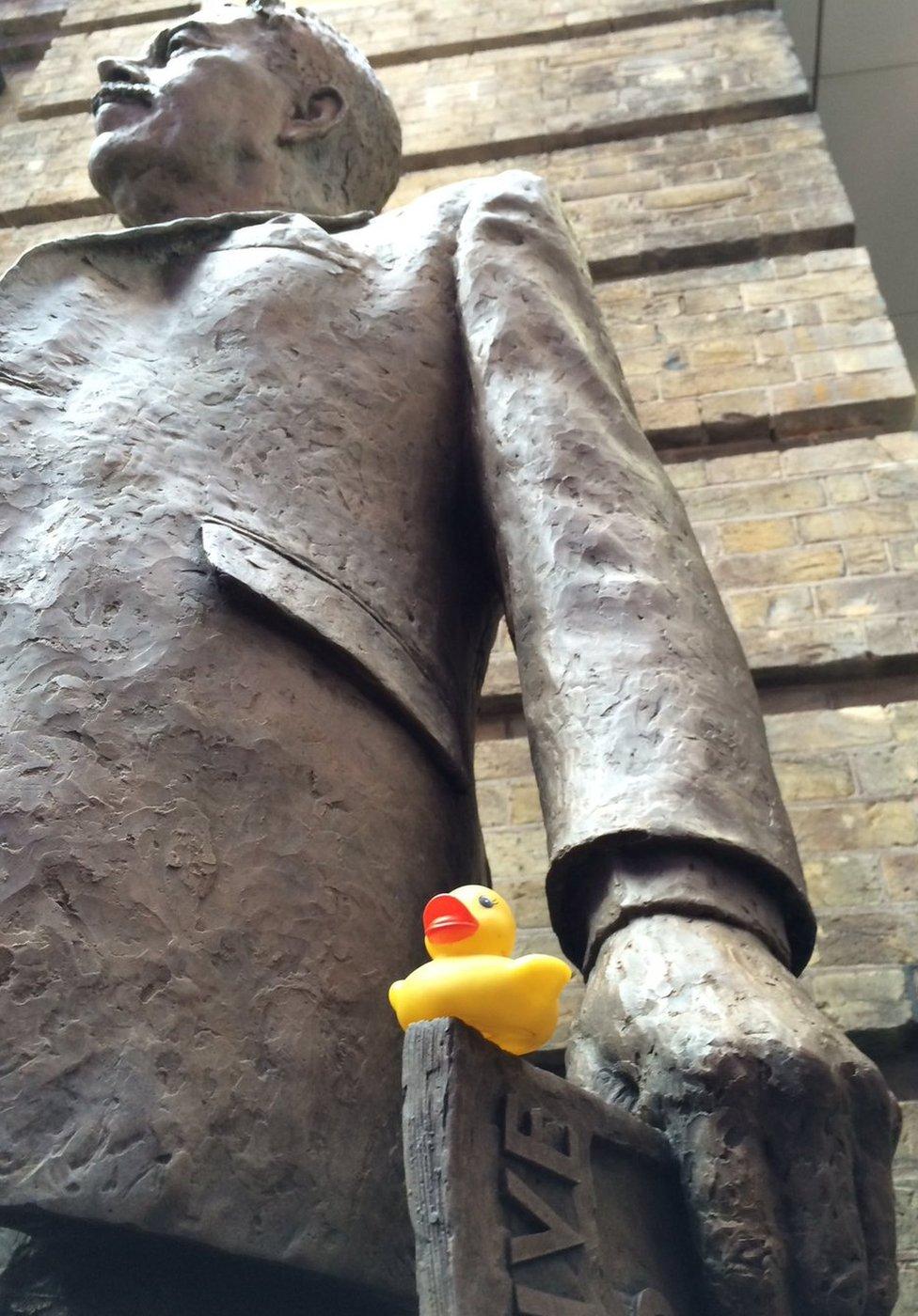 A yellow rubber duck placed on the statue of Sir Nigel Gresley