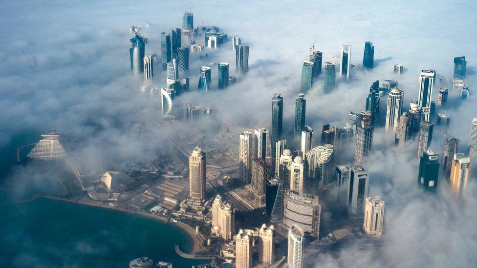 An aerial view of high-rise buildings emerging through fog in Doha, Qatar (15 February 2014)