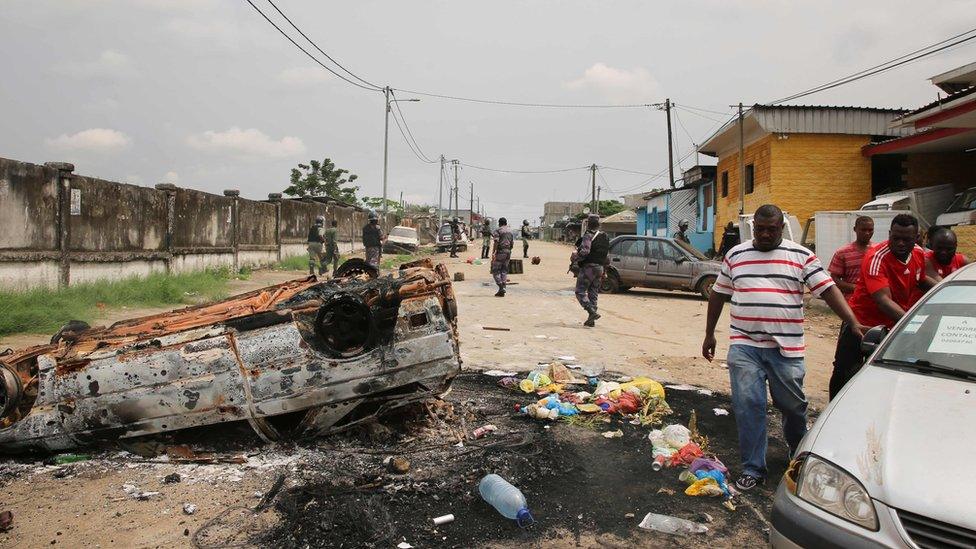 Gabonese gendarmes patrol while people demonstrate in the Cocotiers neighbourhood near the headquarters of the national broadcaster