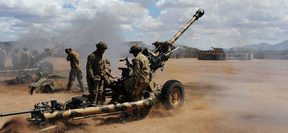 A row of British soldiers fire artillery guns in Kenya