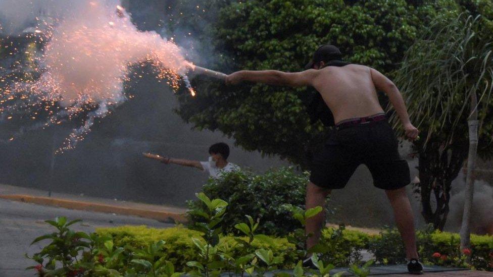 Supporters of Luis Fernando Camacho, the governor of Santa Cruz and a prominent opposition leader, fire firecrackers towards police officers during a protest following Camacho's detention by the Bolivian police, in Santa Cruz de la Sierra, Bolivia December 28, 2022.