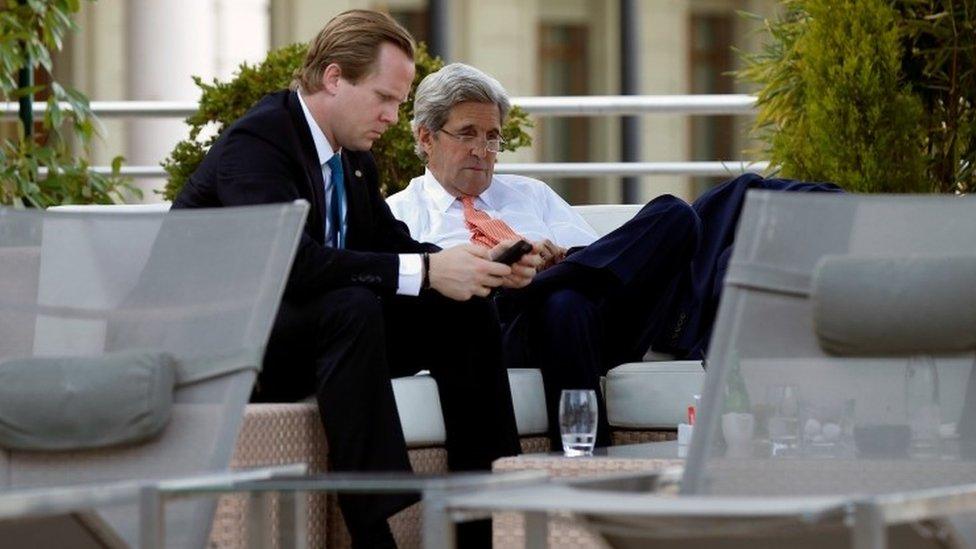 U.S. Secretary of State John Kerry (R) sits beside the hotel pool with aide Jason Meininger during a break from his meeting with Russian Foreign Minister Sergei Lavrov in Geneva