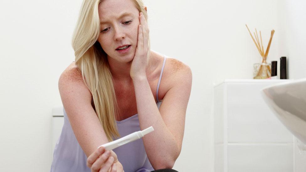 Woman looking at the results of a pregnancy test