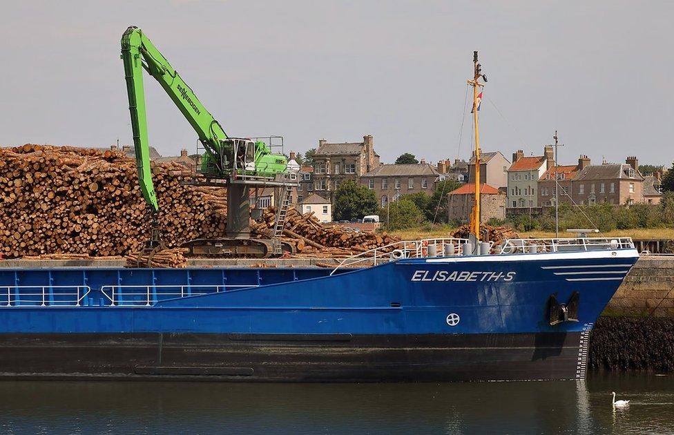 Wood piled up next to a vessel