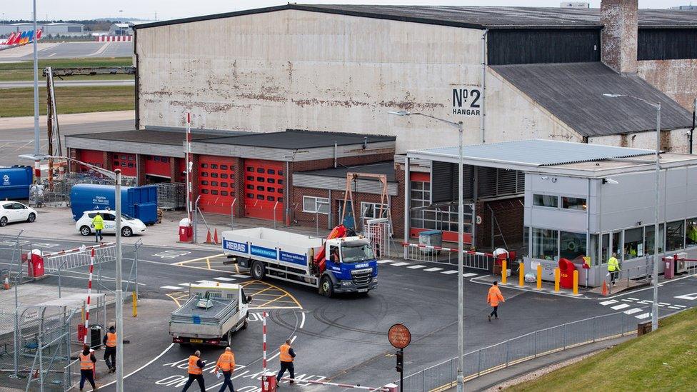 Workers outside a hangar at Birmingham Airport, which is being prepared for use as a temporary morgue during the coronavirus pandemic