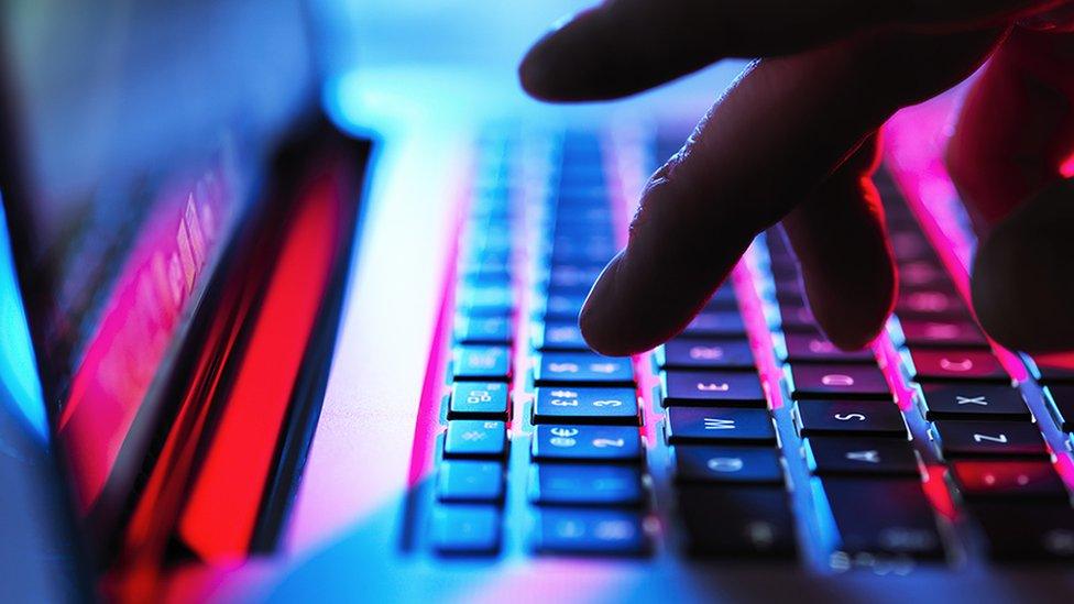 A person typing on a laptop keyboard