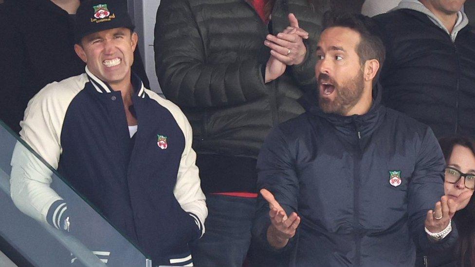 Wrexham owners Ryan Reynolds and Rob McElhenney react during the Vanarama National League fixture between Wrexham and Notts County