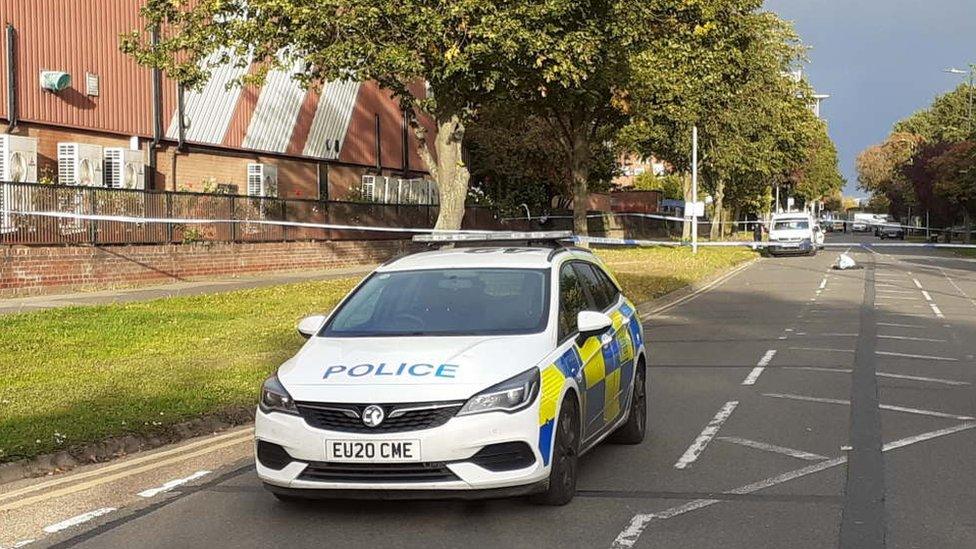 Police car and road cordoned off near to the Oakwood Hill Industrial Estate in Loughton