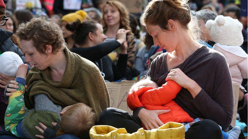 Parents breastfeed their ne borns during a "nuse-in"