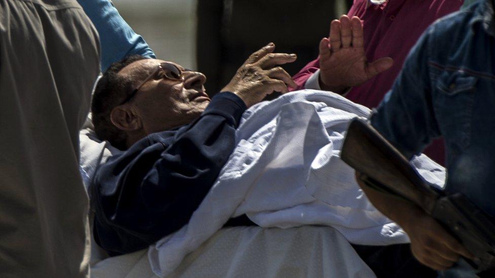 Former Egyptian president Hosni Mubarak is wheeled out of a helicopter into an ambulance outside the Maadi military hospital in Cairo on September 27, 2014 after returning from the court.