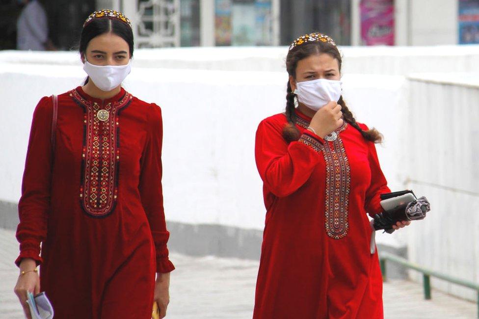 Turkmen women wearing face masks walk in Ashgabat on July 13, 2020. - Reclusive Turkmenistan on July 13 recommended that residents wear masks because of "dust" even as the government insists the country is coronavirus-free.