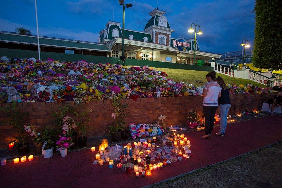 Mourners attend a candlelight vigil outside Dreamworld