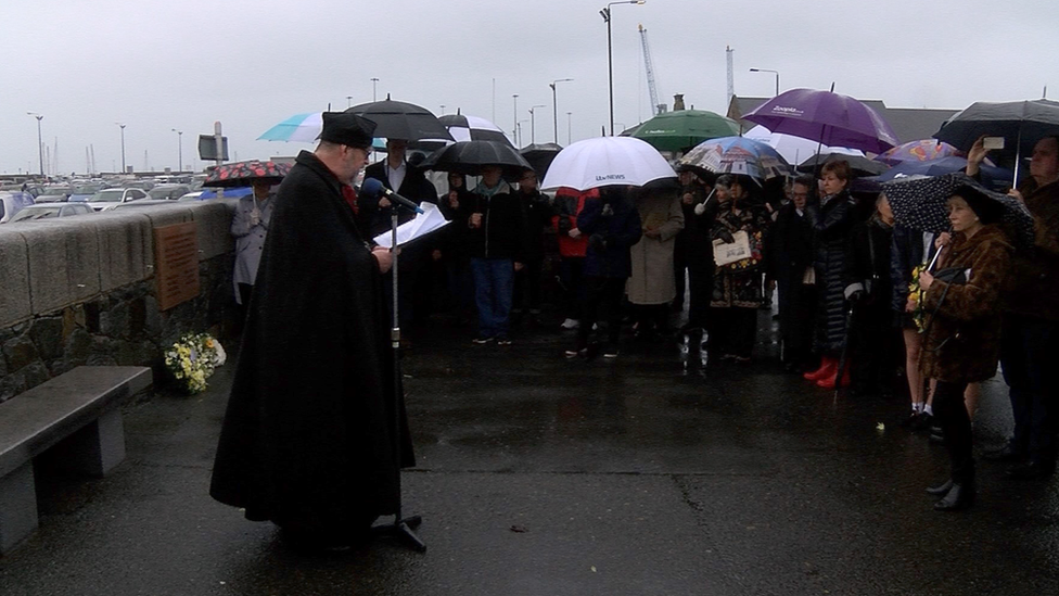 Very Rev Tim Barker, Dean of Guernsey, reading at the island's memorial.