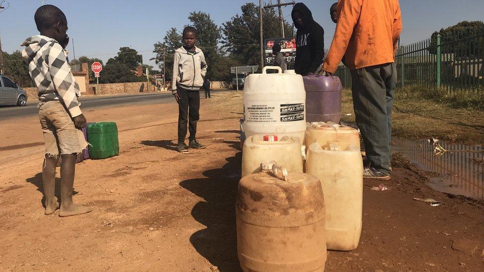 Residents collect water from in Koster