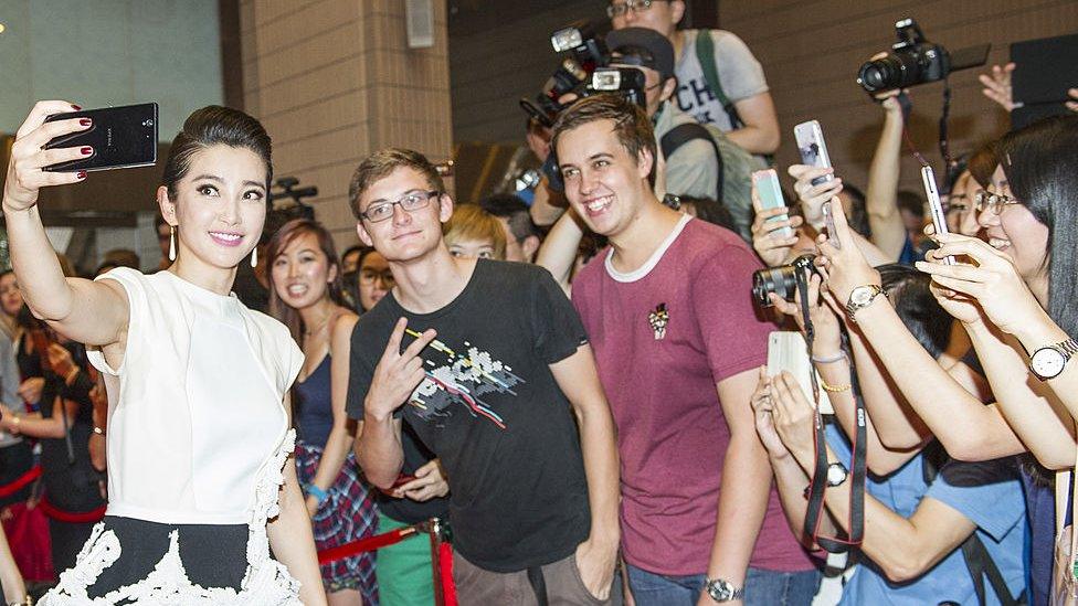 Chinese studios helped finance a Transformers film (Li Bingbing, one of their stars, shown above, holding a camera in a crowd