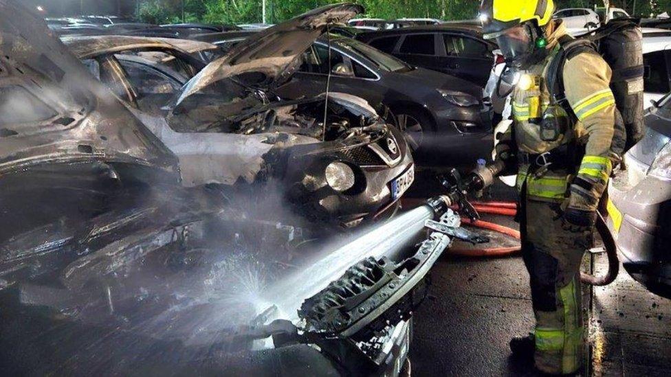 Firefighter tackling vehicle blaze