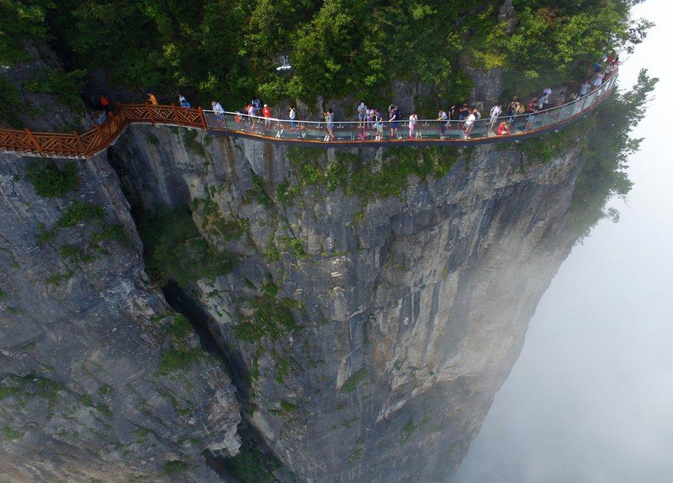 People walk around a glass walkway in Tianmen Mountain in Zhangjiajie National Forest Park, Hunan, China (1 August 2016)