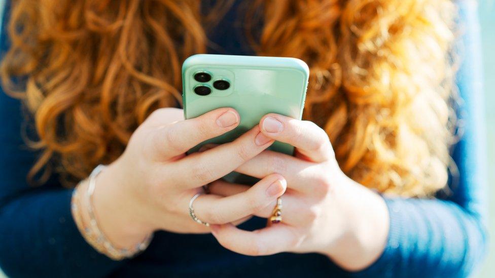 A woman's hands holding a mobile phone