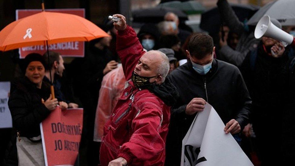 Protesters throw light bulbs during a rally against electricity cuts in Pristina