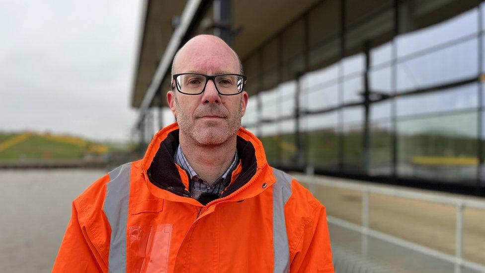 Paul Burrows standing outside the St Germans station wearing a high visibility coat