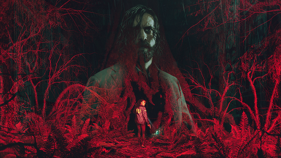 A computer-generated image of a forest made up of gnarled trees, shed of their leaves, and bathed in a menacing red light. A translucent image of Alan Wake, a bearded man with chin-length, straggly hair and wearing a grey suit, is imposed over the top. In the lower part of the image a female wearing a blue jacket with FBI written on the back in yellow letters, looks over her shoulder as she cautiously enters the scene