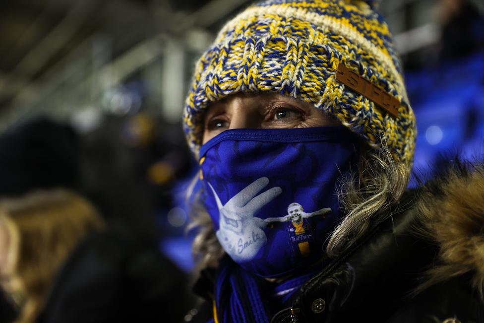 A Shrewsbury Town fan wears a face mask depicting striker Jason Cummings