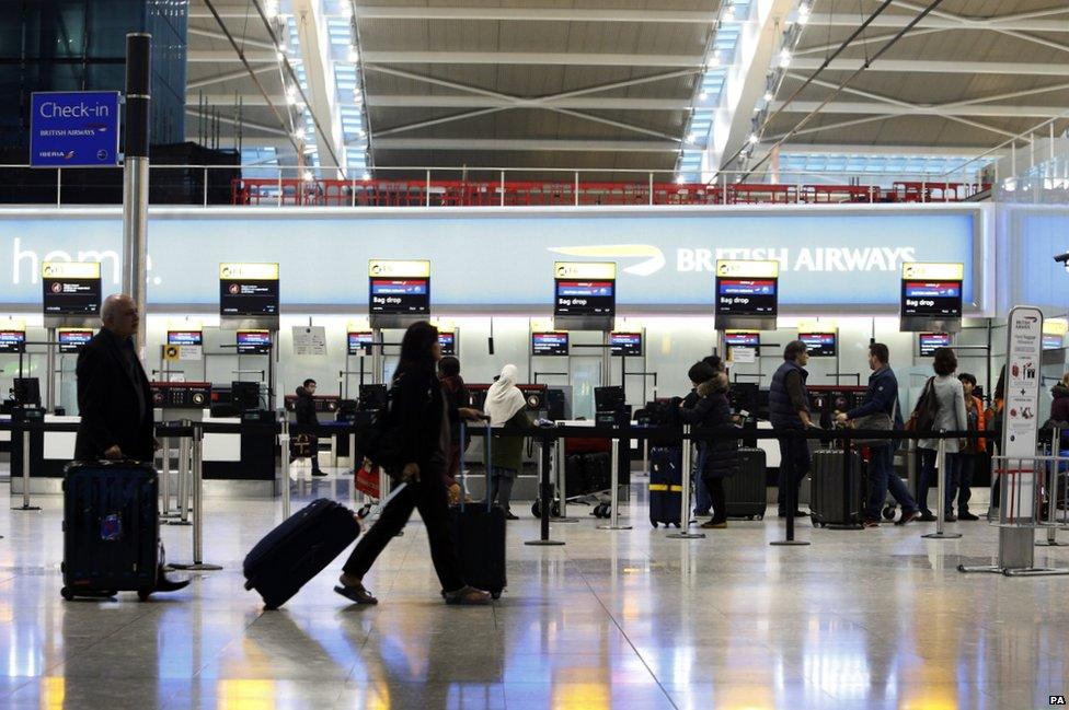 Passengers queue to drop off their bags at Terminal 5