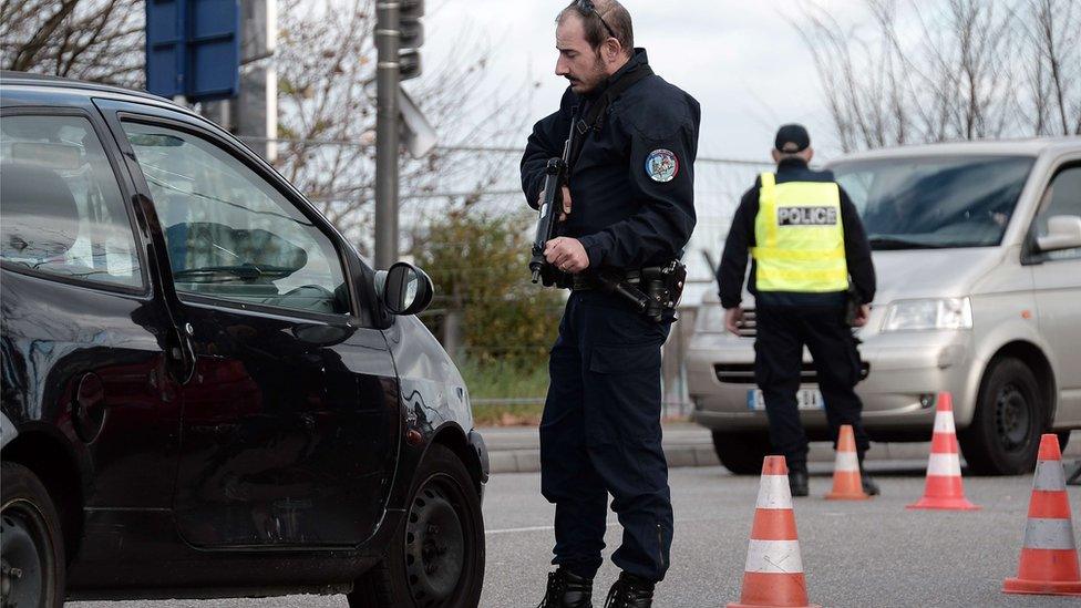 A French police officer stops a car at a checkpoint on the "European bridge" between Strasbourg and Kehl (18 November 2015)