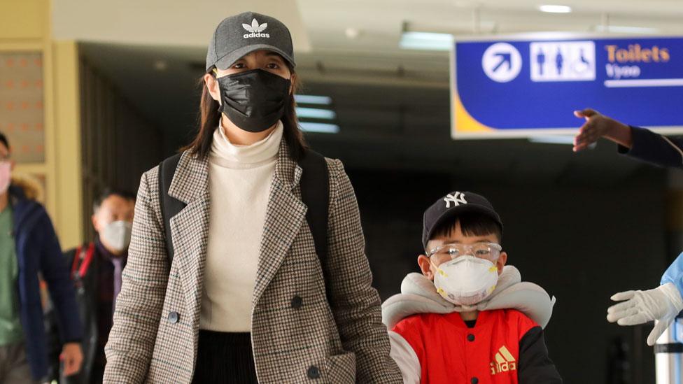 Two people wearing masks